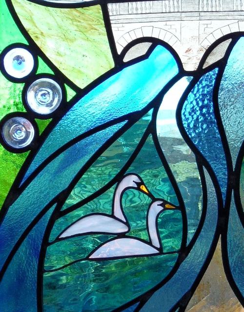 Stained glass swans on water